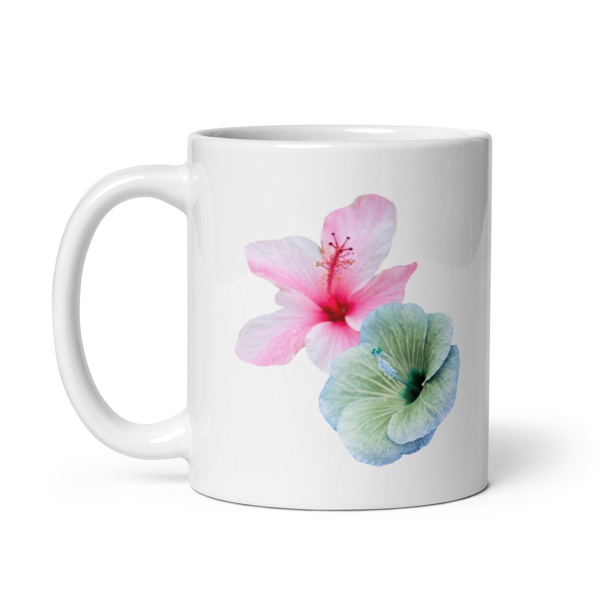 White ceramic mug with soft pink and blue-green hibiscus flowers, floral coffee cup. Side view 2