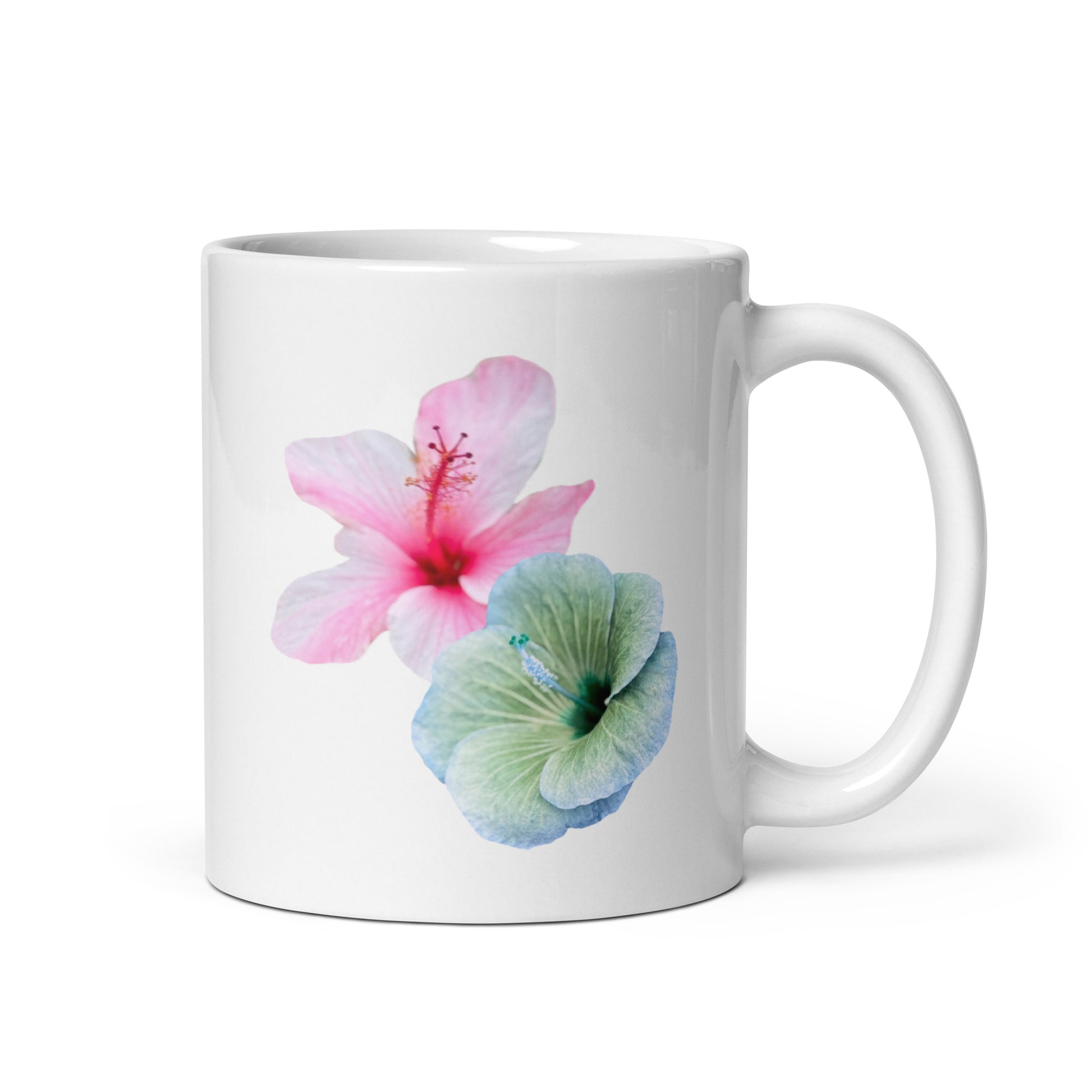 White ceramic mug with soft pink and blue-green hibiscus flowers, floral coffee cup. Side view 1